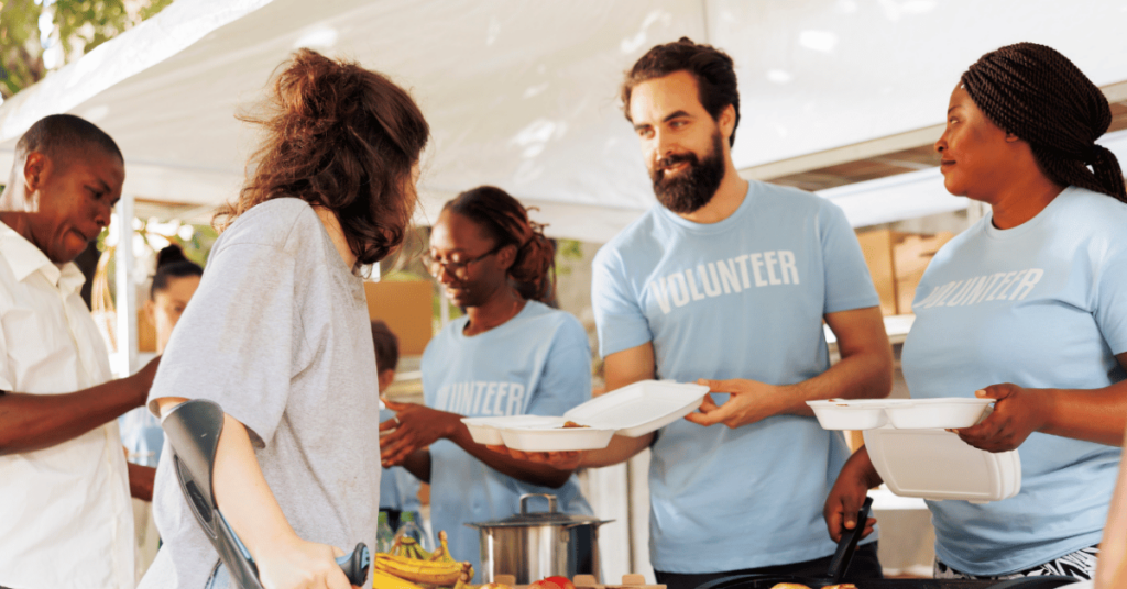 Photo of volunteers smiling and serving food