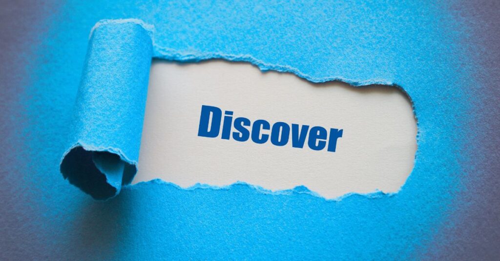 Photo of ripped construction paper revealing the word Discover underneath