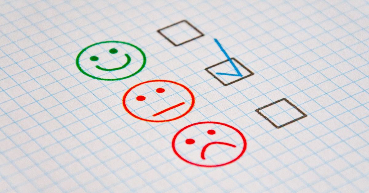 Graphic of line drawn faces next to check boxes - a green smiley face, orange neutral face, and red sad face. The box next to the neutral face is checked.